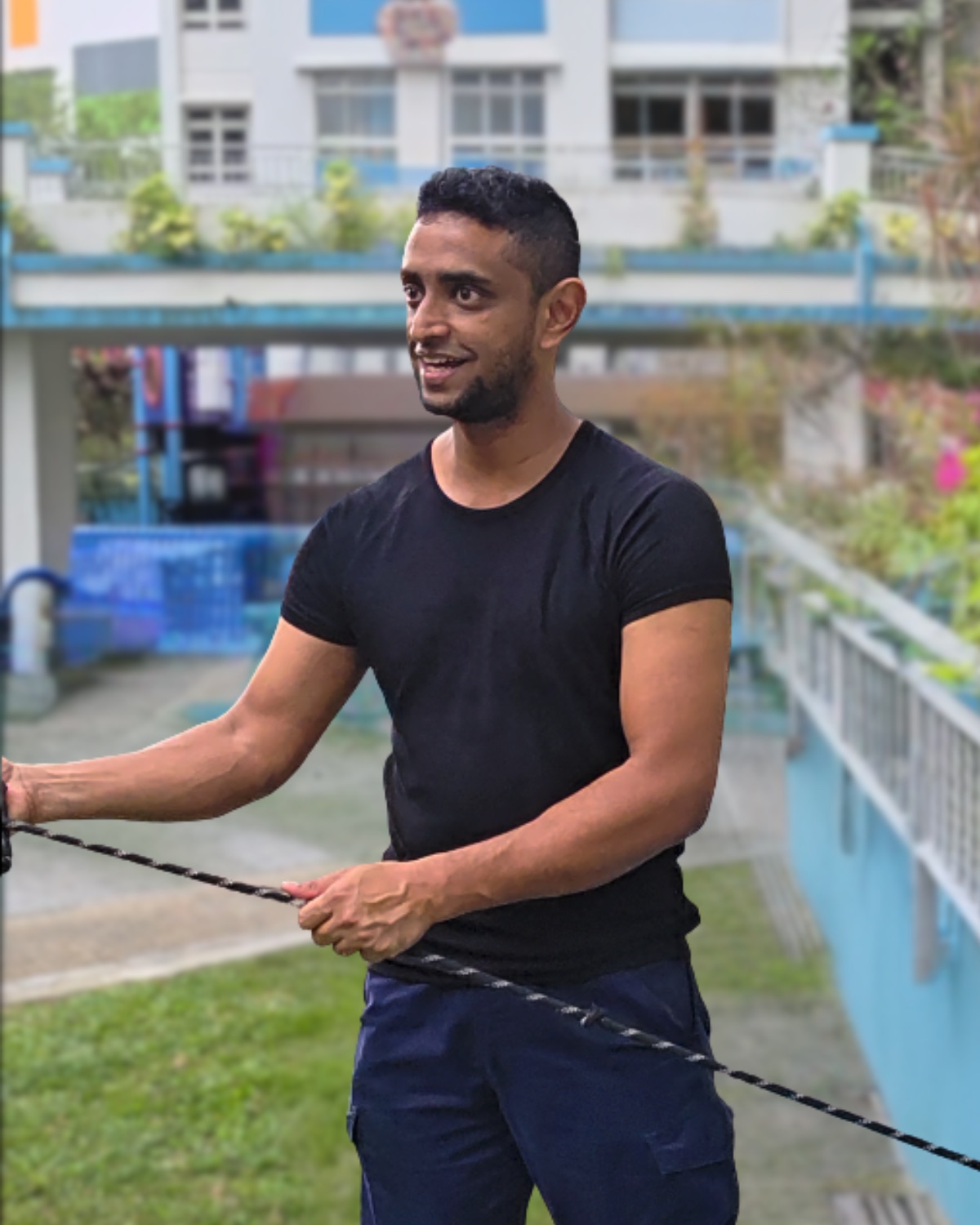 Shawn holding a training lead in a Singapore HDB environment